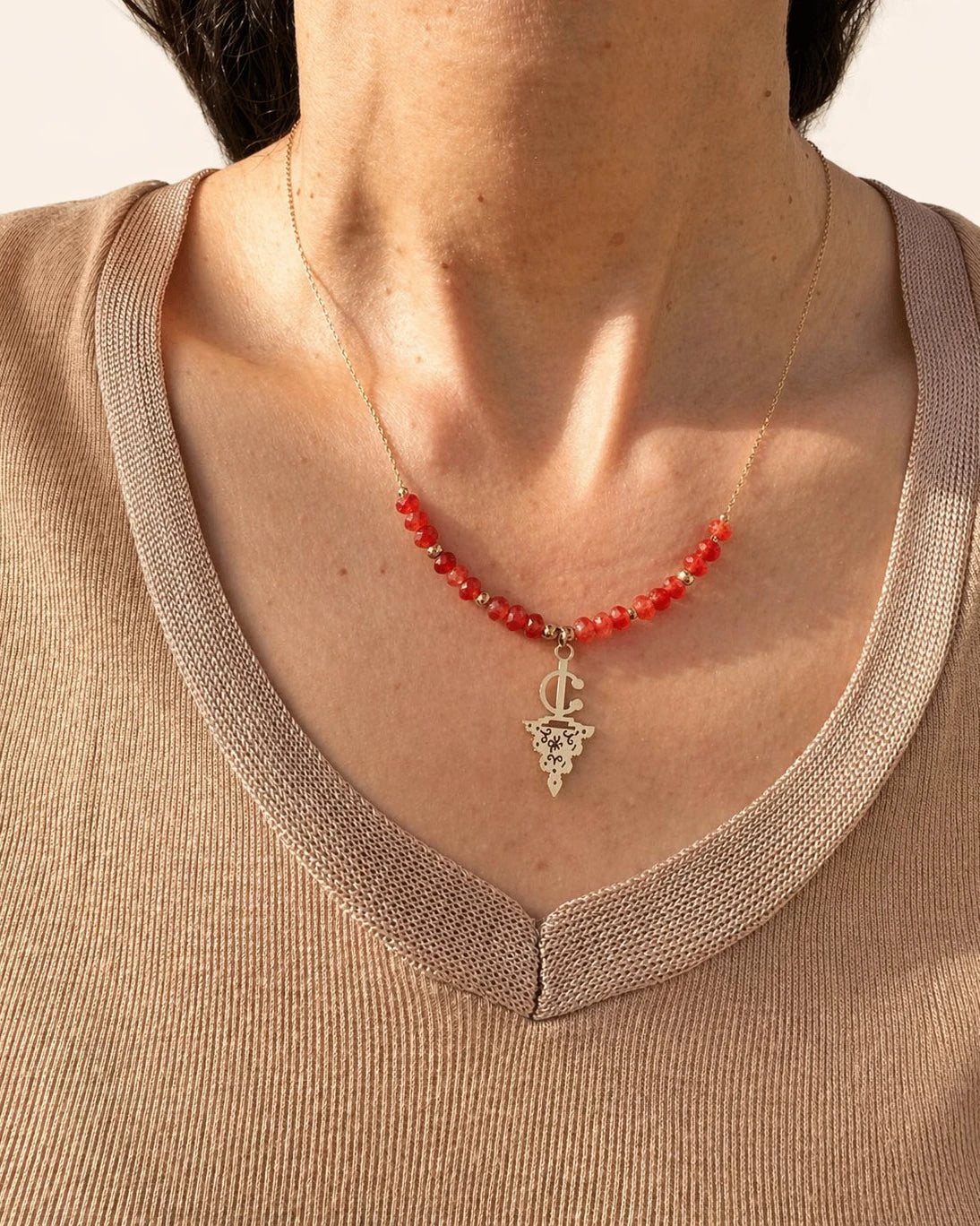 Maisa Amazigh-inspired statement necklace with red beads and a silver-toned fibula pendant on stainless steel.