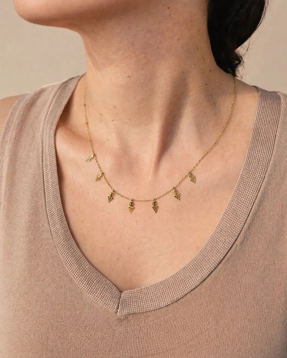 Tajlit necklace in stainless steel with seven mini Amazigh fibula pendants on a beaded chain.